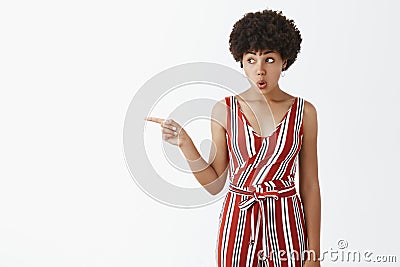 Wow, just look there. Portrait of amazed and impressed curious emotive woman gossiping about neighbour, pointing and Stock Photo