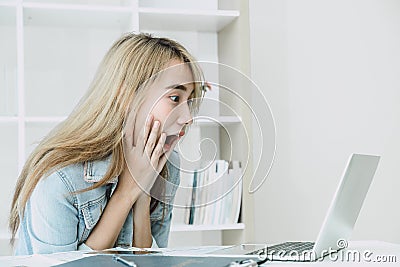 Wow Shock and surprised expression girl when looking at laptop computer screen and see shocking things for good news concept Stock Photo