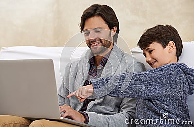 Wow Thats awesome. A young boy and his father playing on a laptop. Stock Photo