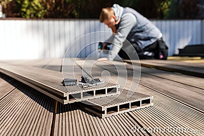 Wpc terrace construction - worker installing wood plastic composite decking boards Stock Photo