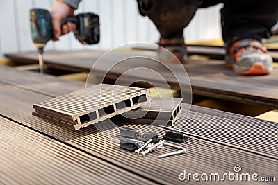 Wpc terrace construction - worker installing wood plastic composite decking boards Stock Photo