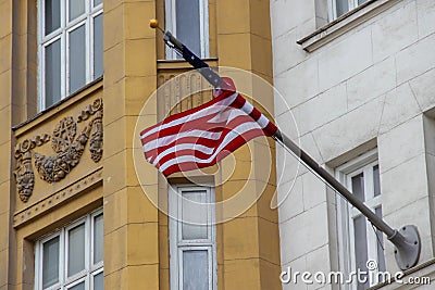 Waving wrapped around flagpole flag of the US, moscow building in stalin empire style Stock Photo