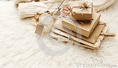 Wrapped craft gift boxes with dry flowers over fur background. Stock Photo