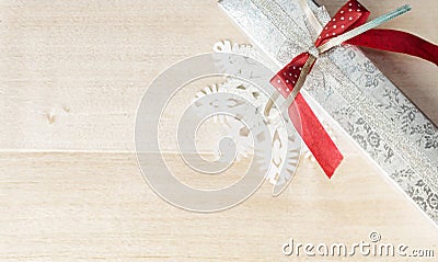 Wrapped gift and paper snowflakes on wood. Christmas siver red b Stock Photo