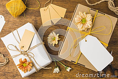 wrapped gift tied with tag string beautiful flower wooden surface. High quality photo Stock Photo