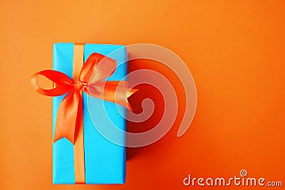 Wrapped present box on orange bright background. Holiday concept. Stock Photo