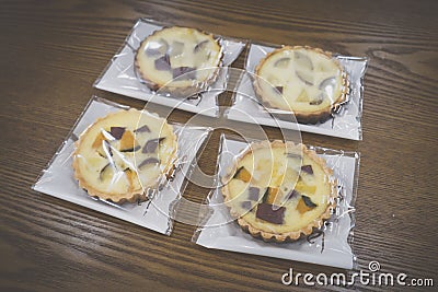 Wrapped sweet pumpkin and sweet potato pies on wooden table Editorial Stock Photo