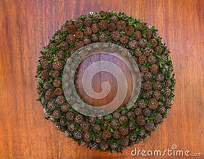 Wreaths on a wooden door made of baby pine cones Stock Photo