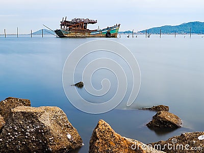 Wreck fishing boat ,sea and mountains Stock Photo