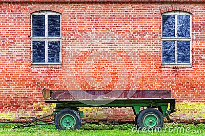 Wrecked trailer and dilapidated brick stable Stock Photo