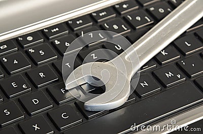 Wrench lying on computer keyboard symbolizing IT maintenance Stock Photo