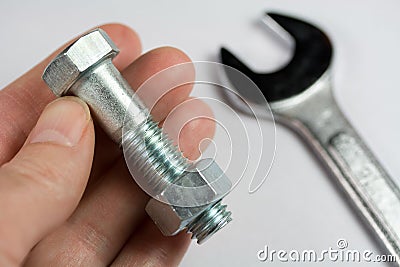 Wrench, Nut and Bolt in Hand Stock Photo