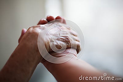 Wrinkled elderly woman`s hand holding to young man`s hand, walking in shopping mall park. Family Relation, Health, Help, Support Stock Photo