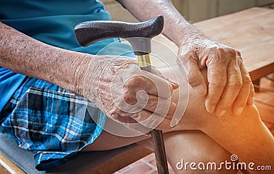 Wrinkled hand of old senior man with a cane stick Stock Photo