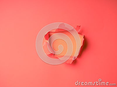 Wrinkled ripped torn red paper with hole in center background texture poster backdrop empty space Stock Photo