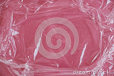 Wrinkled transparent plastic texture on an pink background. Transparent cellophane texture on an pink backing. Top view. Copy, Stock Photo