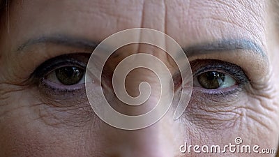 Wrinkled woman looking at camera, eyes close up, anti aging cream, skincare Stock Photo