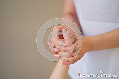 Wrist massage. massage therapist puts pressure on a sensitive point on a woman& x27;s hand. Physiotherapist massaging her Stock Photo