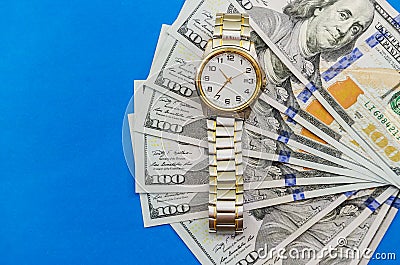 Wrist watch on dollars on blue background close up Stock Photo