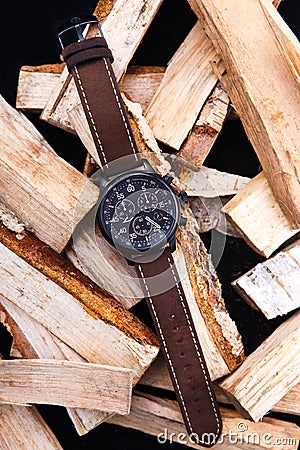 Wrist watch men`s brown leather strap on wood. Stock Photo