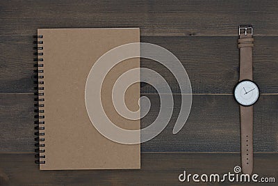 Wristwatch and notebook on wooden table Stock Photo