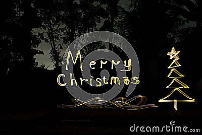 Write christmas greetings with golden lights at night Stock Photo