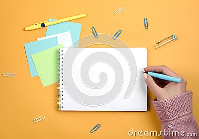Write thoughts and ideas in a clean white notebook on an orange background Stock Photo
