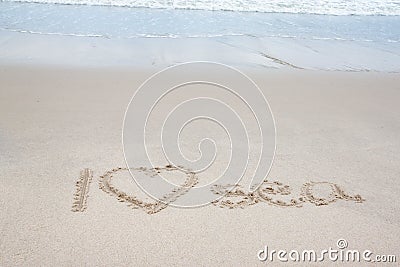 Write the word I Love Sea with wave on the beach. Stock Photo