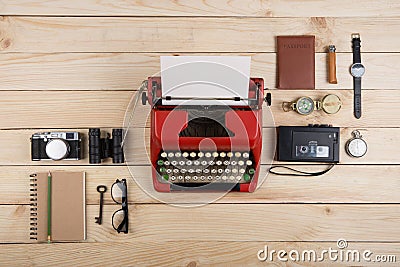 Writer or journalist workplace vintage red typewriter, photo camera, cassette recorder on the wooden desk Stock Photo