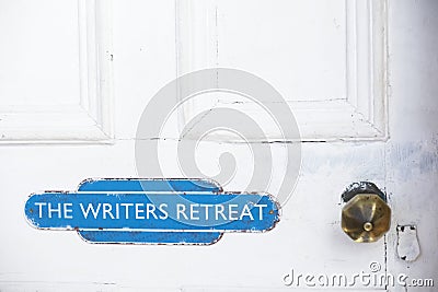 Writers retreat door sign at entrance to quiet room on white weather oak door distressed paint Stock Photo