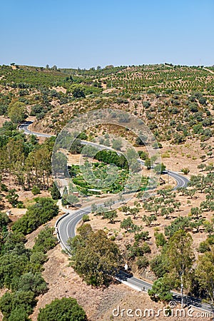 The writhing road winding among olive orchards on the hills. Baixo Alentejo. Portugal Stock Photo