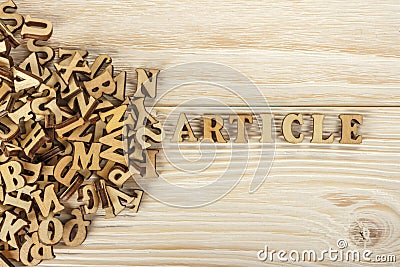 Writing articles. From the pile of letters to create the text for the press. Wooden letters on a wooden background. The view from Stock Photo