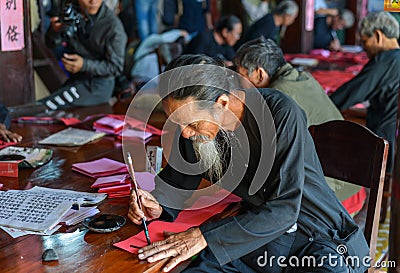 Writing chinese calligraphy on red paper Editorial Stock Photo