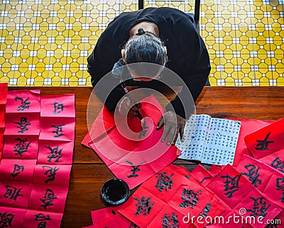 Writing chinese calligraphy on red paper Editorial Stock Photo