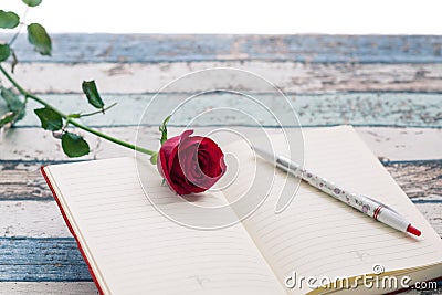 Writing for love: red rose, journal and pen. Stock Photo