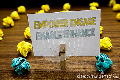 Writing note showing Empower Engage Enable Enhance. Business photo showcasing Empowerment Leadership Motivation Engagement Written Stock Photo