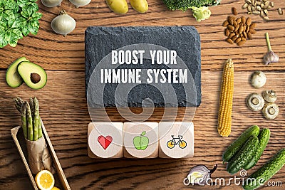 Writing slate with message BOOST YOUR IMMUNE SYSTEM surrounded by vegetables Stock Photo