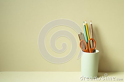 Writing supplies pencil holder on desk. khaki beige background Stock Photo