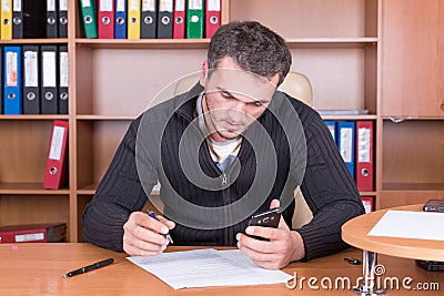 Writing unshaven man in office Stock Photo