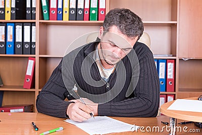 Writing unshaven man in office Stock Photo