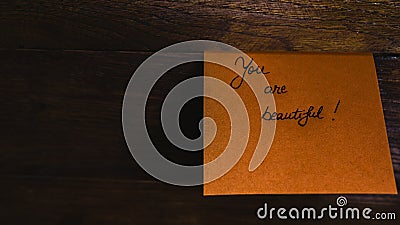 Writing you are beautiful on memo post reminder. Text on sticky paper Stock Photo