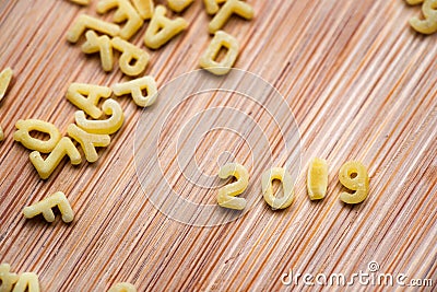 2019 written with alphabet pastas on wood background Stock Photo