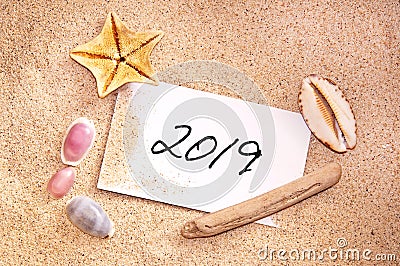 2019 written on a note in the sand with seashells Stock Photo