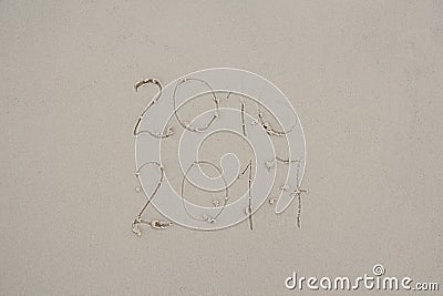 2016 and 2017 written on sand at the beach. 2016 almost washed away by waves Stock Photo