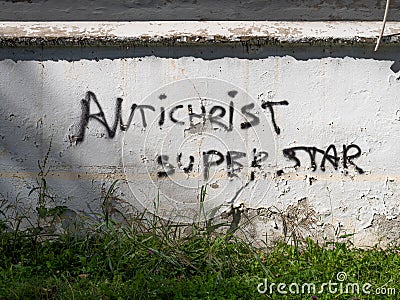 Written on a wall ANTICHRIST SUPERSTAR Stock Photo