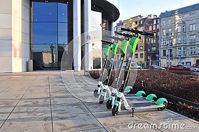 Parked electric scooters `lime`s` on sidewalk . Editorial Stock Photo
