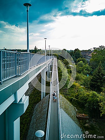 Long concrete footbridge over long street with metal railings at sunny cloudy day Editorial Stock Photo