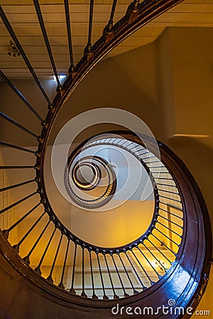 Beautiful renovated old wooden spiral staircase inside old and high tenement building with glowing Editorial Stock Photo