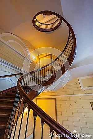 Beautiful renovated old wooden spiral staircase inside old and high tenement building with glowing Editorial Stock Photo