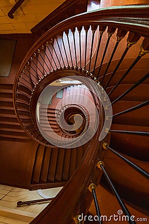 Beautiful renovated old wooden spiral staircase inside old and high tenement building with glowing Editorial Stock Photo